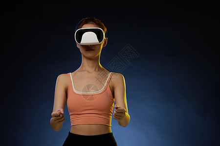带着VR眼镜打虚拟游戏的女青年图片