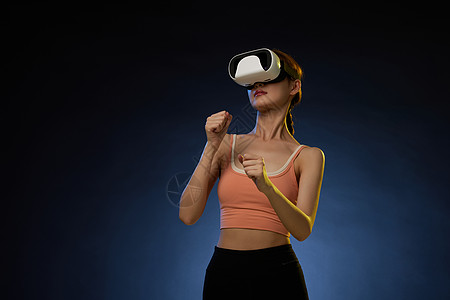 打VR拳击运动游戏的年轻女青年图片