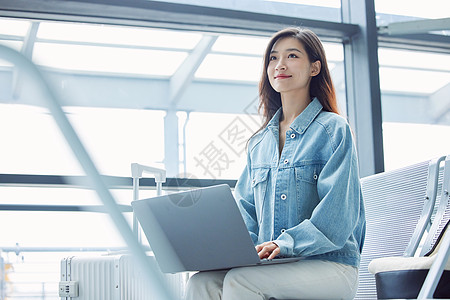 女性在候机厅使用笔记本电脑高清图片