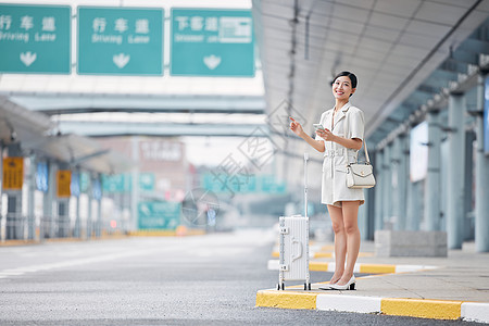 一个人的旅行等候车辆的商务女性背景