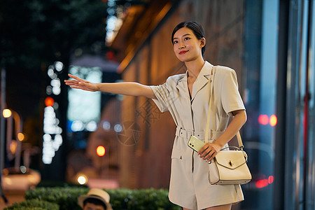 职场女强人夜晚室外叫车的商务女性背景