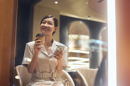 深夜加班咖啡店内使用手机的商务女性背景