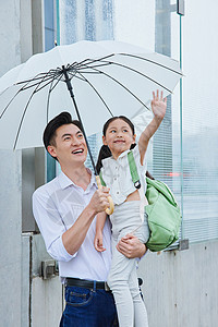 儿童雨伞年轻爸爸抱着刚放学的小女孩背景