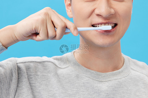 男性刷牙时牙齿特写图片