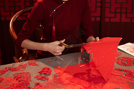 喜庆中国穿旗袍的年轻女子剪窗花背景