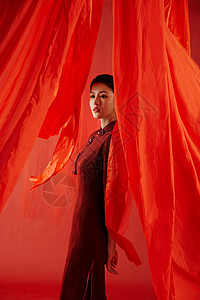 中国红丝绸红色飘带背景中的旗袍美女形象背景