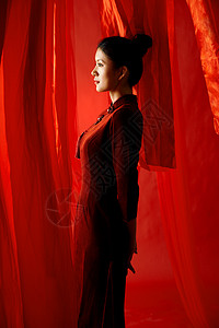 红色飘带背景中的旗袍美女侧颜图片