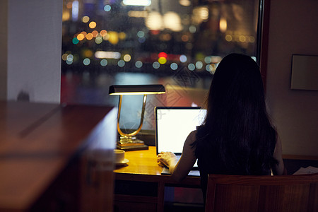 熬夜加班的女孩年轻白领夜晚居家办公背影背景