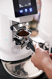 咖啡师操作磨粉机特写图片