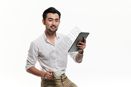 手拿平板电脑端着咖啡杯的男人图片