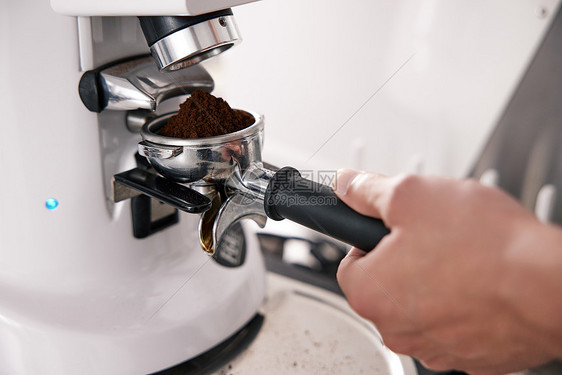 用磨粉机磨咖啡粉特写图片