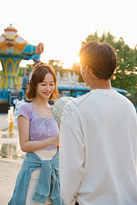 甜蜜来袭结果男朋友递来的棉花糖的年轻女孩背景