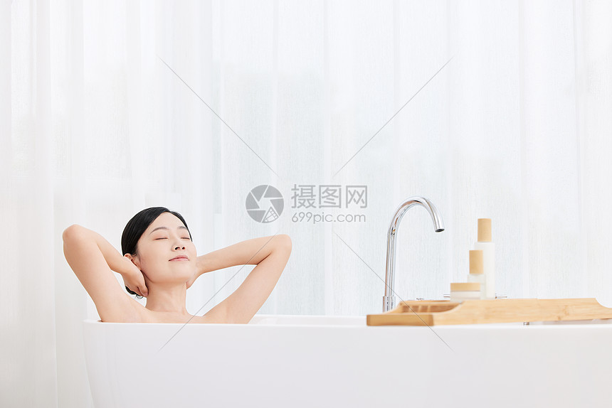 青年女性躺在浴缸享受泡泡浴图片