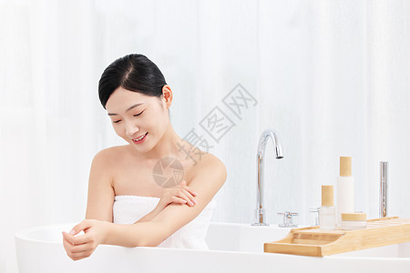 年轻女性沐浴后使用身体乳护肤高清图片