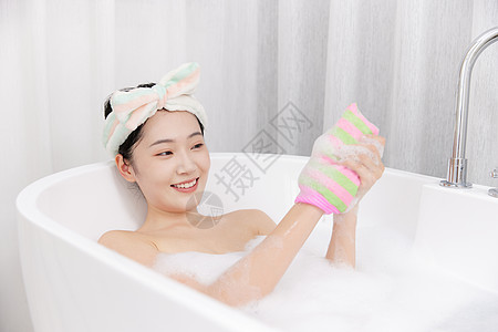 年轻女性居家泡澡使用搓澡巾高清图片