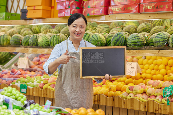 超市水果店店员手拿小黑板推销图片