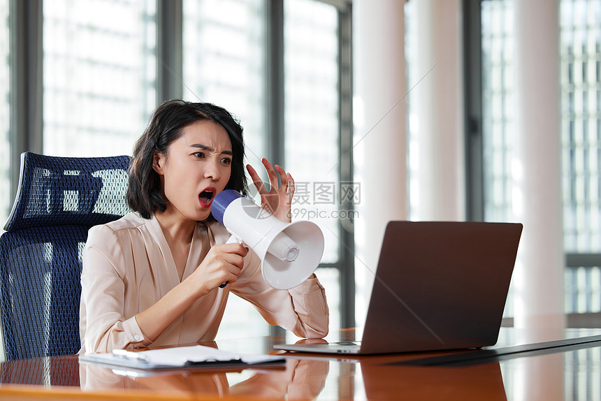 职场女性拿着扩音器对着电脑大叫图片