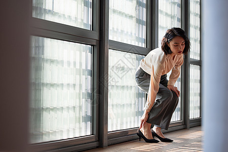 商务女性穿高跟鞋按摩脚部图片