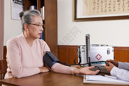 医生上门陪护为老奶奶测量血压背景图片