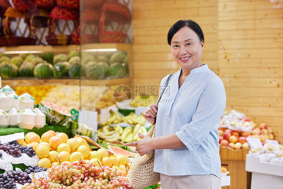 水果店购买水果的中年女性图片