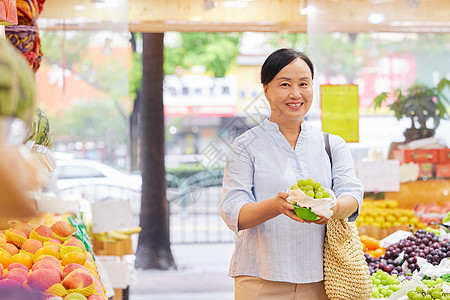 中年女性水果店内手拿葡萄图片