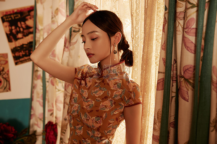 整理身上装饰的旗袍美女