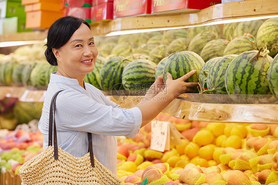 中年女性水果店内挑选西瓜图片