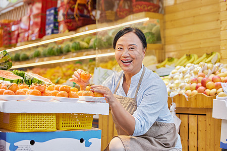 中年水果店员工检查橘子图片