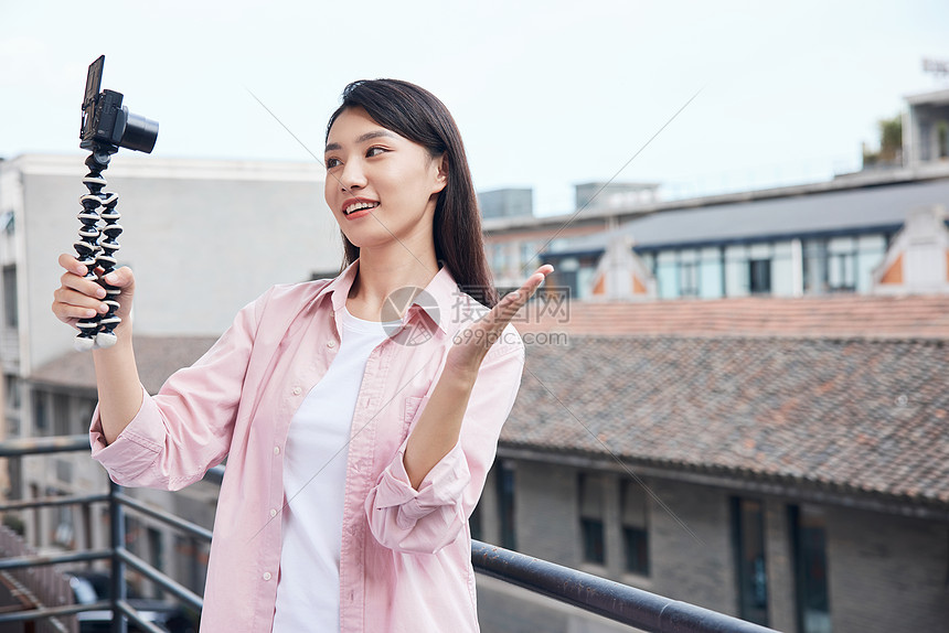 女视频博主拿相机户外拍摄图片