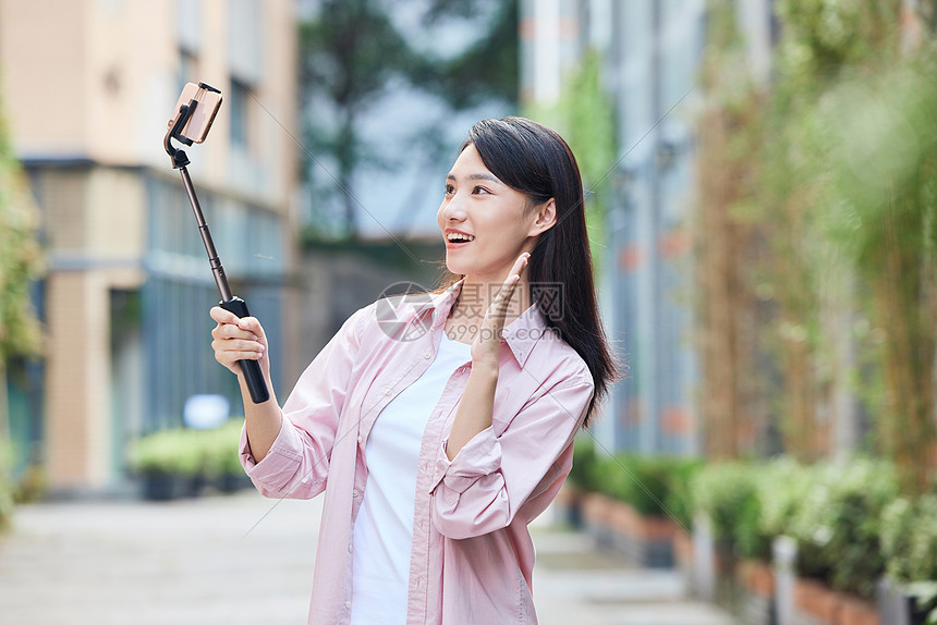 青年女主播户外录对镜头打招呼图片