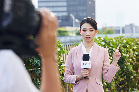 青年女记者户外采访录制背景图片