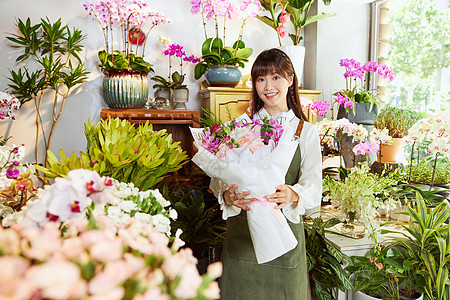 女性手捧鲜花花艺店美女服务员手捧鲜花花束背景