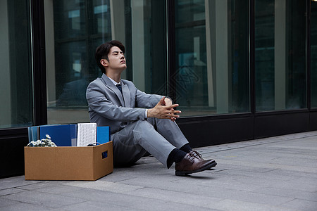 开除失业的职场商务男性瘫坐在地上背景