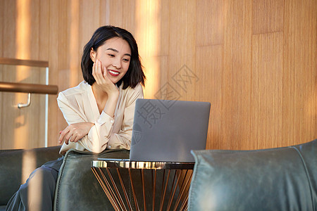 职场美女女性在休闲区域使用笔记本电脑背景