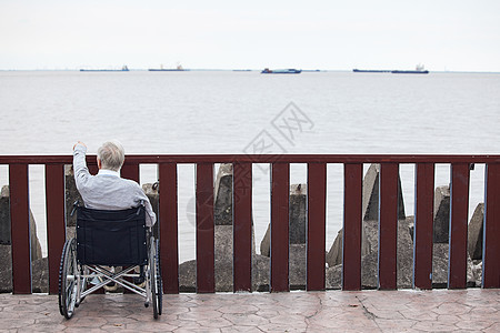 孤独看海的轮椅老人背影图片
