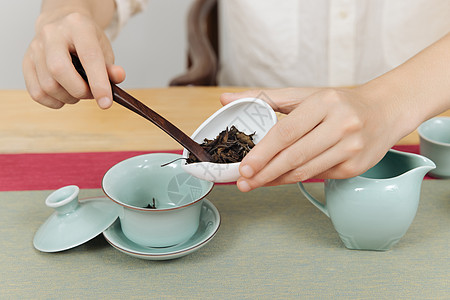 男性往茶杯里加茶叶特写高清图片