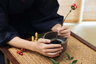 日系男性手拿花枝插花特写图片