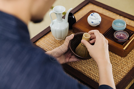 意大利粉日系男性手拿茶筅筛茶特写背景