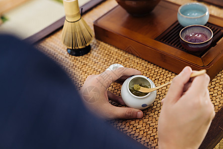 茶杯茶盘茶具茶艺师使用茶勺取抹茶粉特写背景