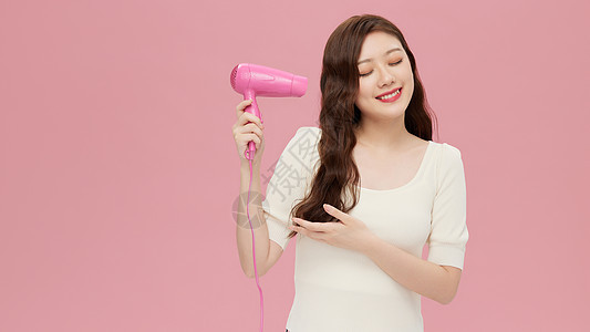 活力韩系女性手拿吹风机图片