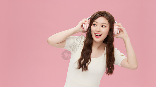 带耳机听音乐的青年女性背景图片