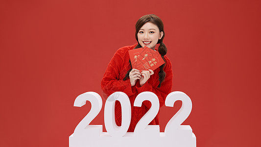 献礼赢新春活力女性手拿红包迎接2022年背景