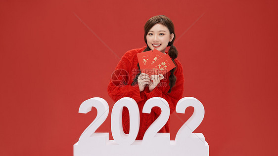 活力女性手拿红包迎接2022年图片