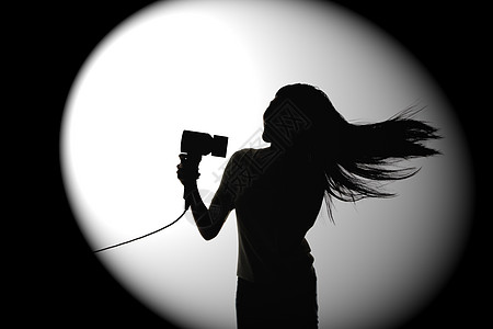 摄像机剪影使用吹风机的女性剪影背景