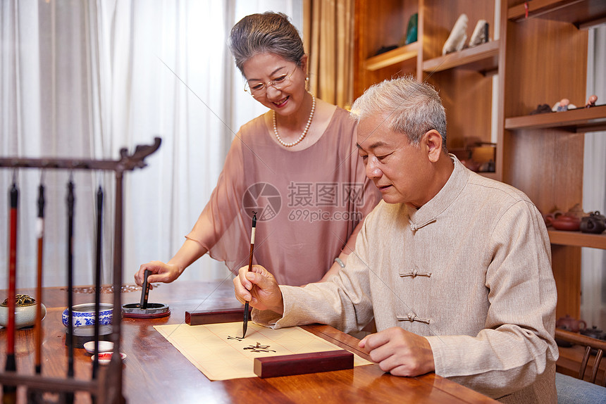 老奶奶在家陪伴老爷爷练习书法图片
