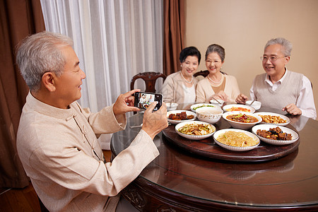 中秋节手机老友聚会一起吃饭使用手机拍照背景