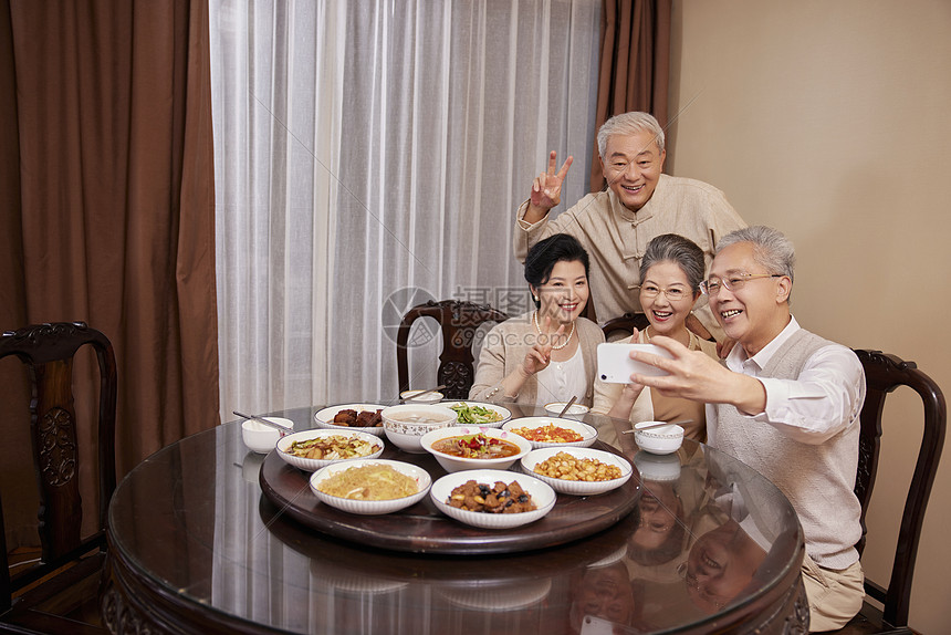 老友聚会一起吃饭使用手机合照图片