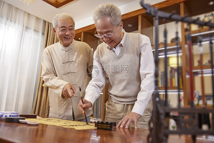 老年人聚会在家探讨书法图片