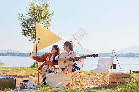 秋天湖边年轻美女露营弹吉他自拍背景