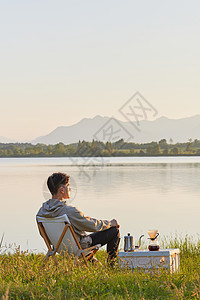 男青年坐在湖边享受大自然图片